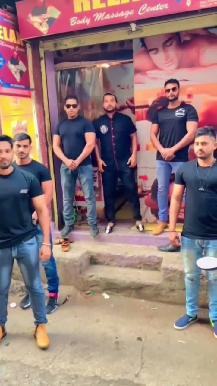 A group of men standing outside the centre's shopfront in Nanded, below the Relax Body Massage Center signboard.